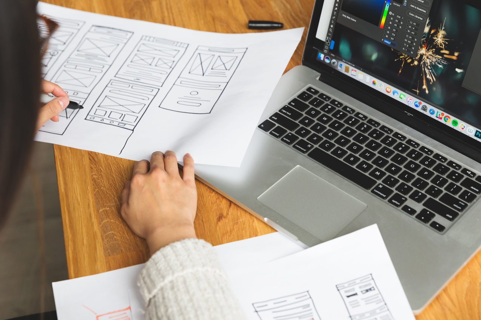 A designer working at a desk, reviewing wireframe documents  -  illustrative stock photo